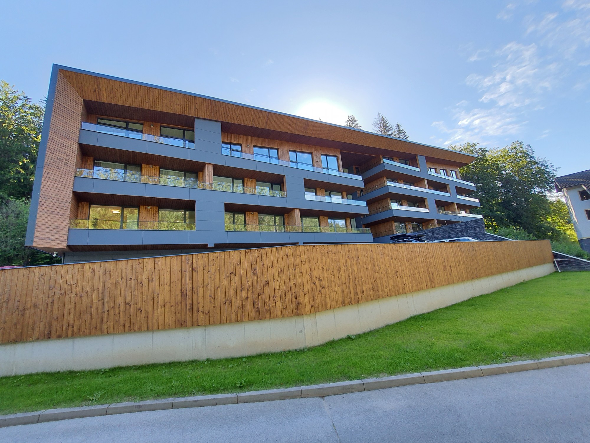 sklenené zábradlie na balkónoch apartmánového domu kotvené v zapustenom podlahovom profile
